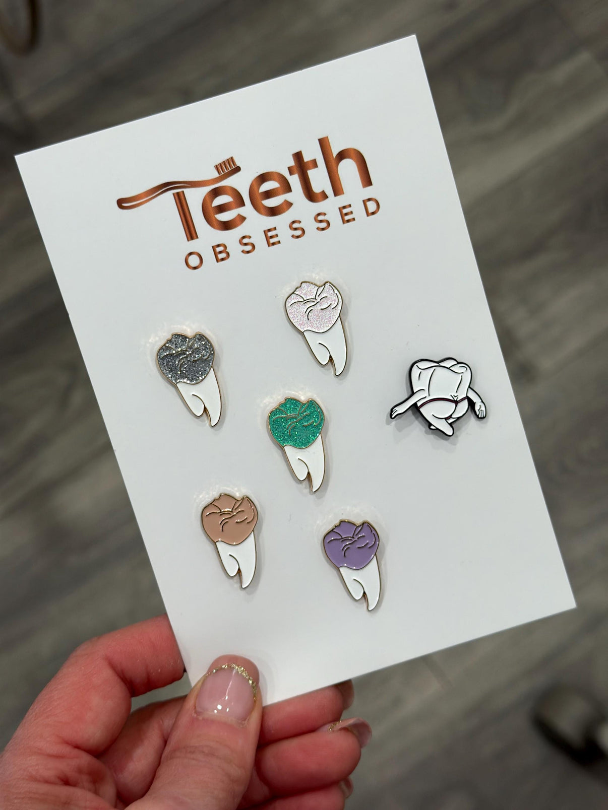 Teeth Obsessed molar enamel pin on a shirt, showcasing a detailed white enamel molar tooth pin with a shiny finish.