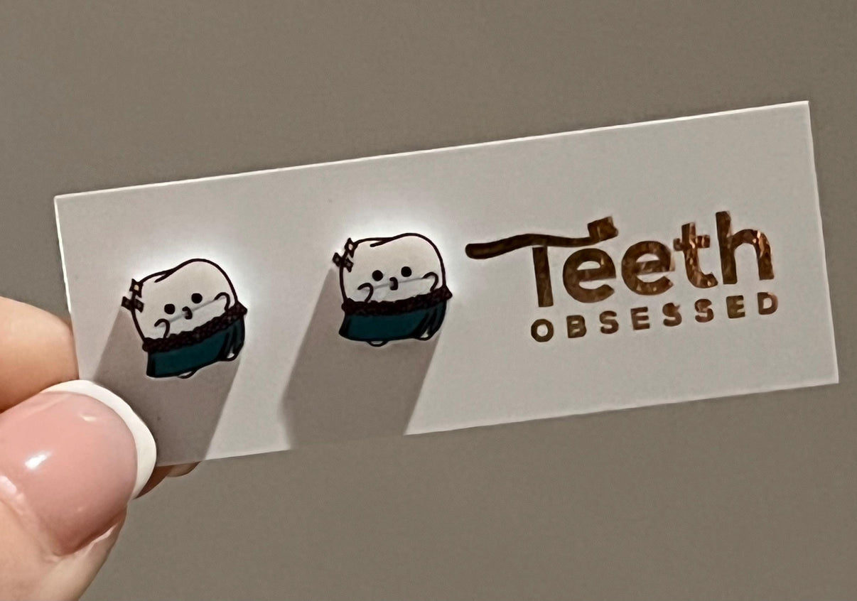 Teeth Obsessed Hula Tooth Dental Earrings featuring playful dental-themed jewelry with hula girl design, silver tone finish.