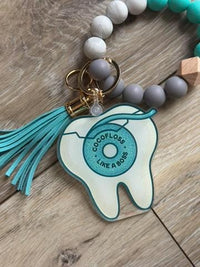 Teeth Obsessed Flossboss dental floss keychain with attached floss container and keyring for easy oral hygiene on the go.