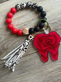 Teeth Obsessed Dental Rose keychain featuring a small pink rose and dental-themed design on a metal keyring.