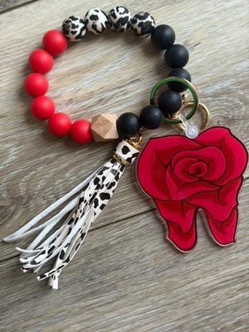 Teeth Obsessed Dental Rose keychain featuring a small pink rose and dental-themed design on a metal keyring.