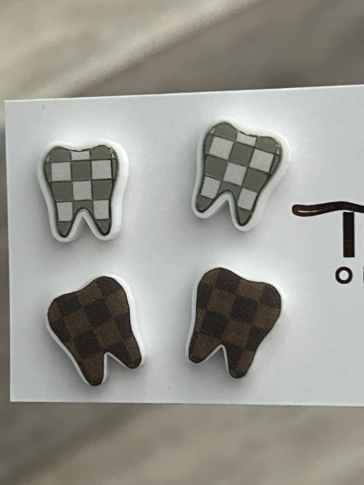 Check Tooth Dental Earrings by Teeth Obsessed featuring realistic tooth-shaped earrings on display.