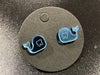 Whale-shaped dental earrings by Teeth Obsessed featuring silver-tone whale charms on fishhook earrings.