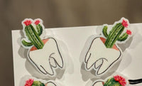 Dental earrings featuring succulent tooth designs by Teeth Obsessed, showcasing a close-up of the unique jewelry piece.