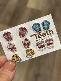 Teeth Obsessed Wonderland Dental Earrings featuring whimsical cat-shaped dental jewelry with colorful enamel accents.