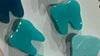 Dark turquoise teeth-themed dental earrings by Teeth Obsessed, featuring a playful dental motif in a vibrant color.