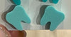 Dark turquoise dental earrings by Teeth Obsessed featuring tooth-shaped designs and a stylish, modern jewelry look.