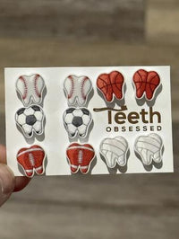 Teeth Obsessed sports ball tooth earring resembling a football, made as a unique dental jewelry accessory.