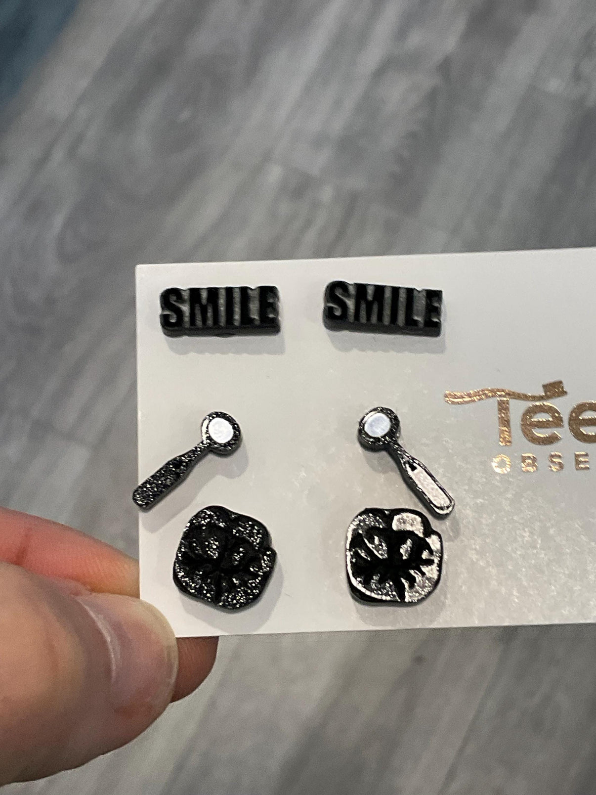 Teeth Obsessed dental earrings featuring a mirror, smile, and molar design in metal, stylish jewelry for dental enthusiasts.