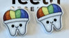 Rainbow Tooth Earrings by Teeth Obsessed featuring colorful dental-themed earrings with rainbow-colored teeth design.