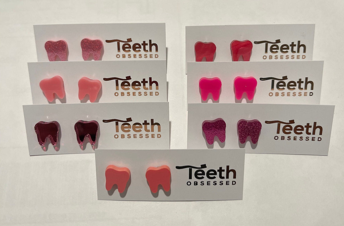 Pink glitter dental stud earrings featuring tooth shapes from Teeth Obsessed, perfect for a fun, bold accessory.