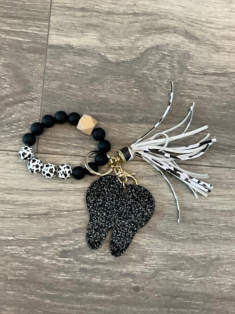 Set of dental keychains featuring a cow, cheetah, and brown leopard tooth designs from Teeth Obsessed.