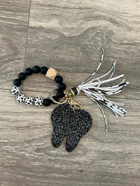 Set of dental keychains featuring a cow, cheetah, and brown leopard tooth designs from Teeth Obsessed.