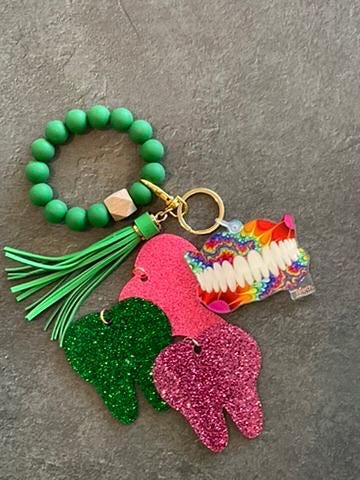 Dark green Rainbow Denture Keychain from Teeth Obsessed, a colorful dental accessory with a tooth design.