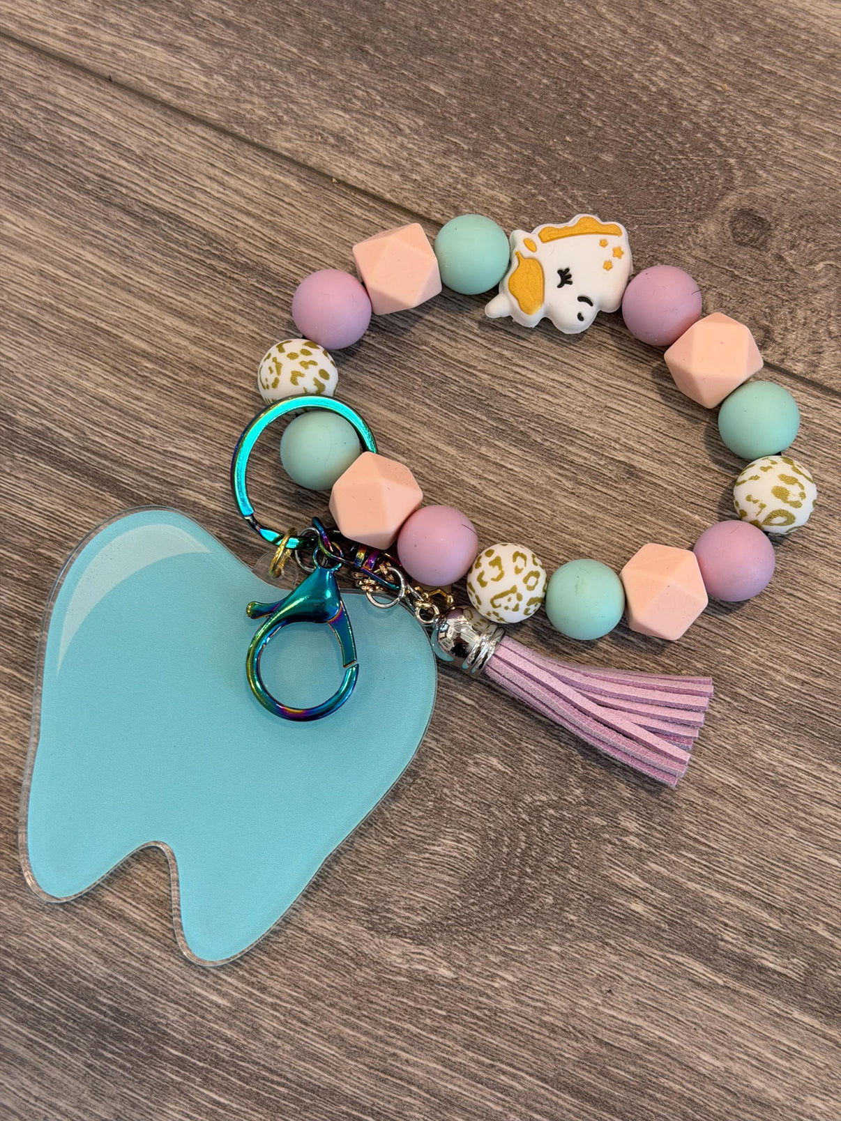 Mint Tooth Unicorn dental keychain from Teeth Obsessed featuring a cute unicorn design on a mint green background.