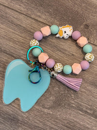 Mint Tooth Unicorn dental keychain from Teeth Obsessed featuring a cute unicorn design on a mint green background.