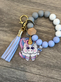 Unicorn-shaped dental keychain from Teeth Obsessed featuring a colorful unicorn design and dental-themed details.