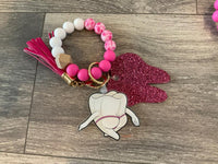 Mrs Flossy and Friends dental keychain by Teeth Obsessed featuring a cute flossing character and a tooth-shaped charm.