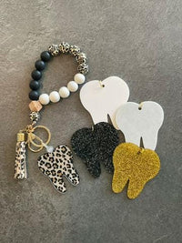 Gold Cheetah Tooth Keychain from Teeth Obsessed dental keychain collection, featuring a sleek cheetah design and tooth motif.