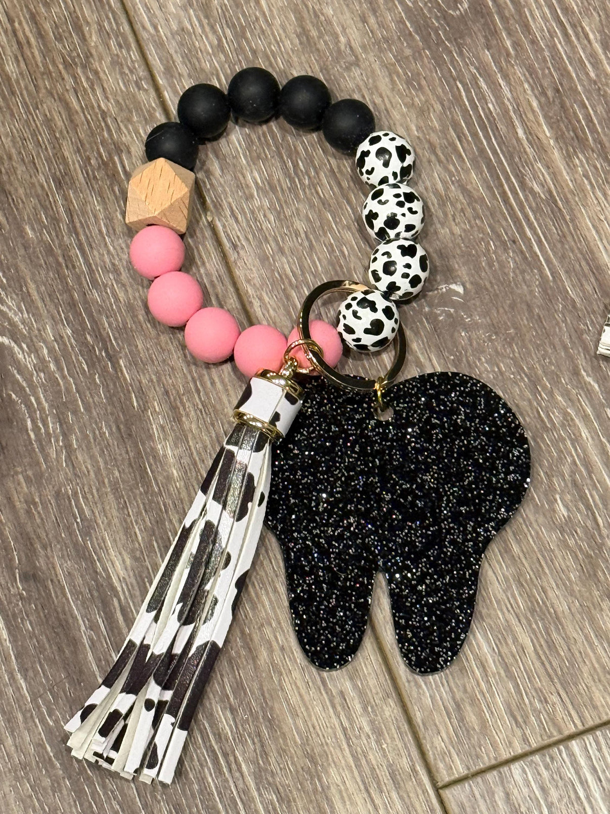 Pink cow-shaped dental keychain made of handmade acrylic, featuring a tooth design by Teeth Obsessed.