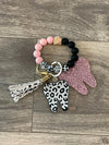 Pink and teal leopard print dental keychains featuring teeth design from Teeth Obsessed, perfect for accessorizing keys or bags.