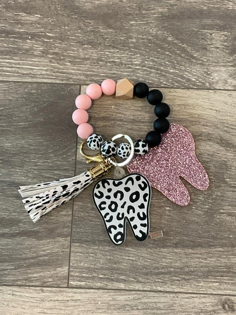 Pink and teal leopard print dental keychains featuring teeth design from Teeth Obsessed, perfect for accessorizing keys or bags.