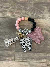 Pink and teal leopard print dental keychains featuring teeth design from Teeth Obsessed, perfect for accessorizing keys or bags.