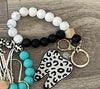 Pink and teal leopard print dental keychains featuring fun tooth-shaped designs from Teeth Obsessed.