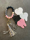 White leopard tooth dental keychain from Teeth Obsessed featuring a realistic tooth design and animal print pattern.