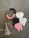 White leopard tooth dental keychain by Teeth Obsessed, featuring a realistic tooth design on a keyring.