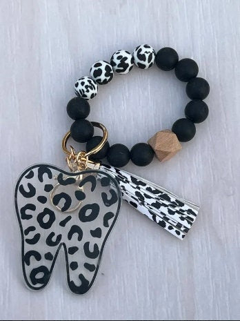 Teeth Obsessed leopard print tooth keychain, dental hygiene gift, with realistic tooth design and stylish animal print pattern.