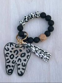Teeth Obsessed leopard print tooth keychain, dental hygiene gift, with realistic tooth design and stylish animal print pattern.