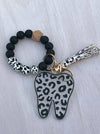 Leopard print teeth-shaped keychain from Teeth Obsessed, a fun dental hygiene gift accessory with a stylish pattern.