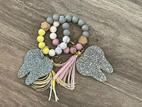 Silver glitter tooth keychain with pink and yellow accents, from Teeth Obsessed dental keychains collection.