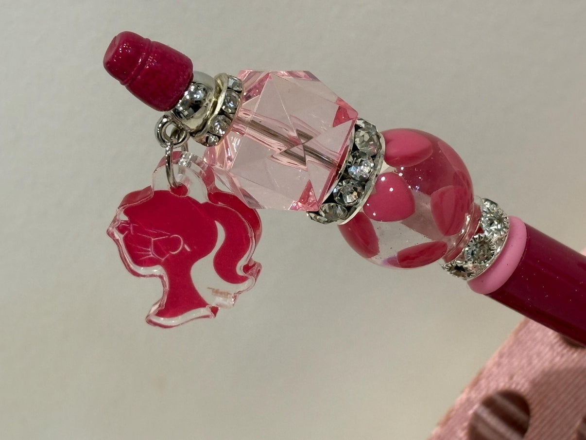 Pink dental team charm with loupes on Teeth Obsessed dental pens and holders, featuring detailed dental professional figures.