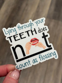 Funny dental sticker from Teeth Obsessed featuring the phrase "Lying Isn't Flossing," perfect as a dental gift or decoration.