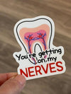 Glitter dental sticker from Teeth Obsessed with the phrase "You're Getting On My Nerves" on a white background.