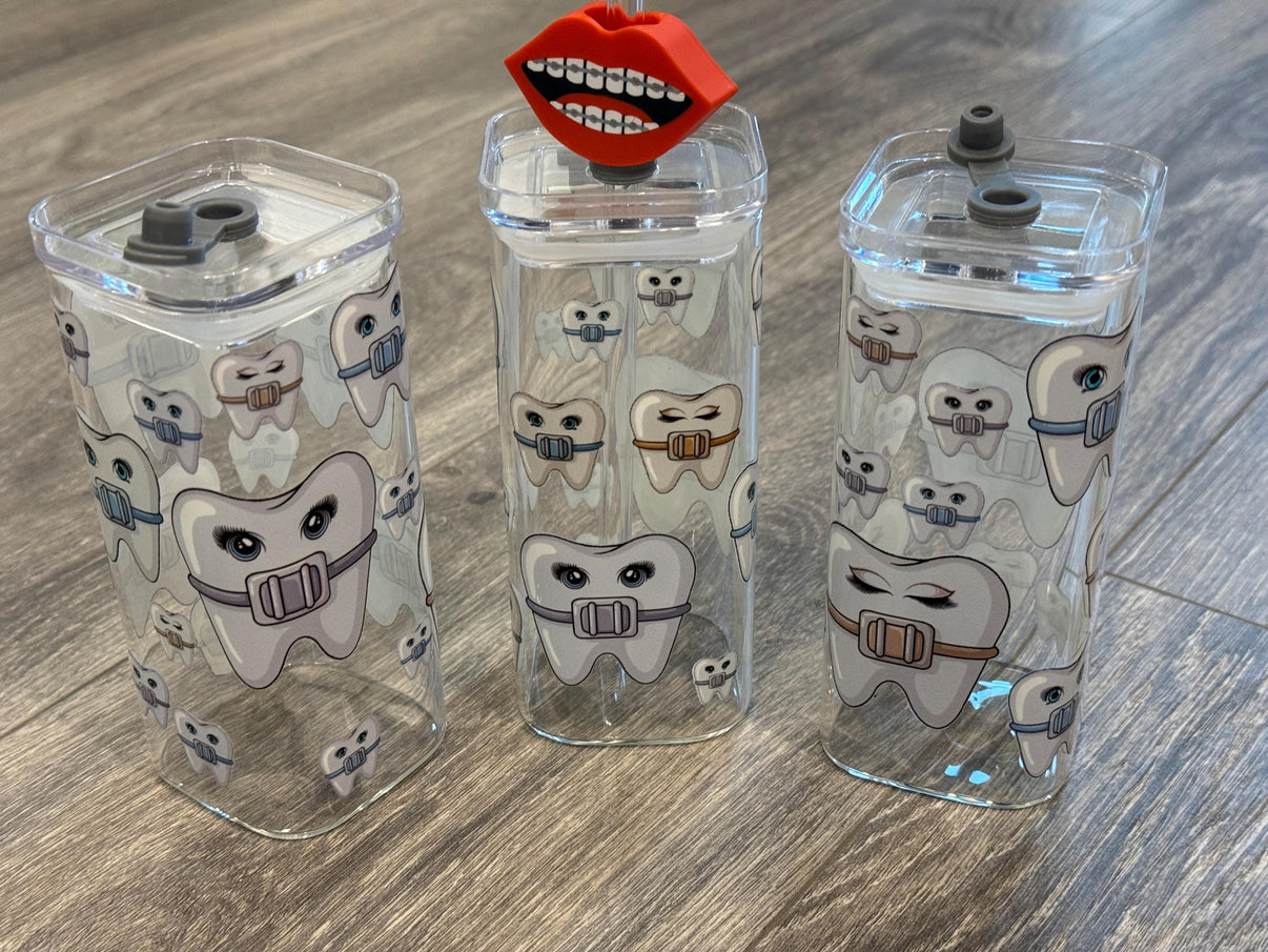 Teeth Obsessed orthodontic braces-themed drinkware with cups and toppers featuring tooth and braces designs.