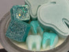 Turquoise Teeth Obsessed soy wax melts in freshies, vents, and tart shapes, featuring a playful tooth design.