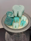 Turquoise Teeth Obsessed Tooth Wax Melts in freshie, vent, or tart form made from soy wax, displayed with a bikini bottom shape.