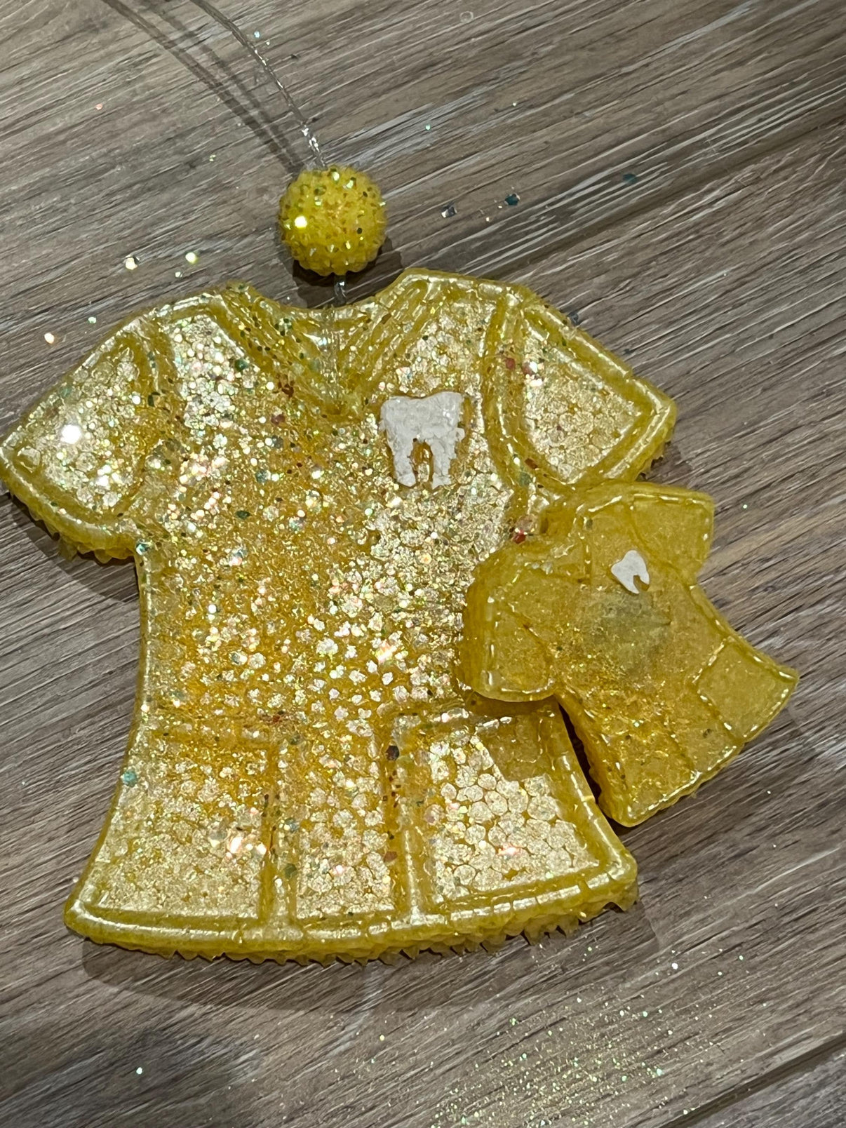 Teeth Obsessed yellow scrub top and vent car freshener with tart scent, designed for freshening car air and adding a pop of color.