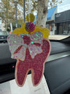 Pink and yellow Teeth Obsessed tooth-shaped car freshener, vent freshie with peach scent and vibrant colors.