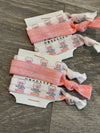 Light pink Dental Nerves hair tie by Teeth Obsessed, a stretchy hair accessory designed for secure hair styling.