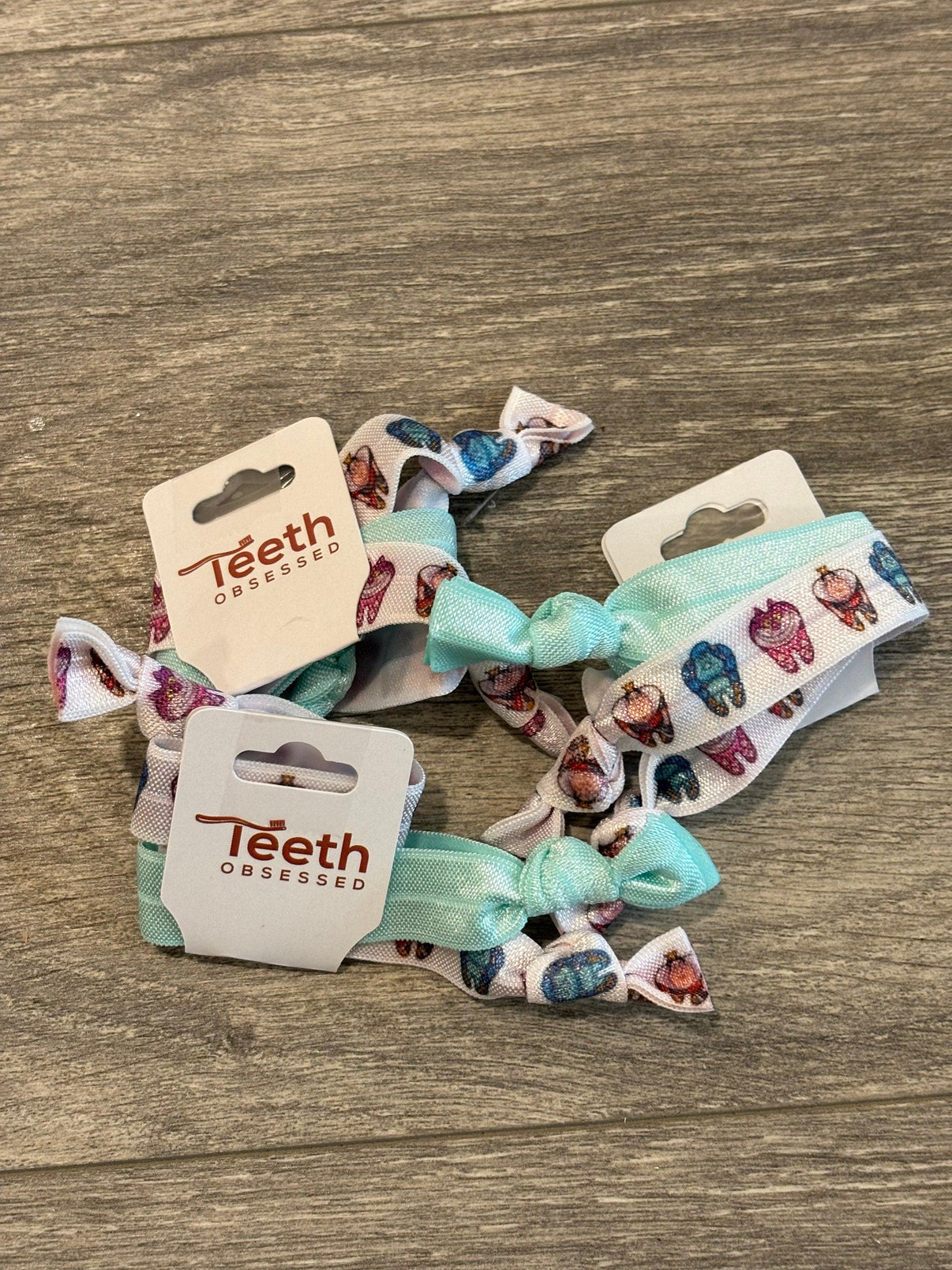 Teeth Obsessed Dental Wonderland Hairtie in bright, colorful hair ties with dental-themed design, suitable for securing hair comfortably.
