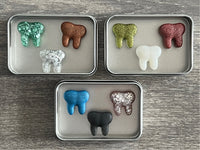 Blue glittering acrylic tooth magnet from Teeth Obsessed, used as dental office decor or notes holder.