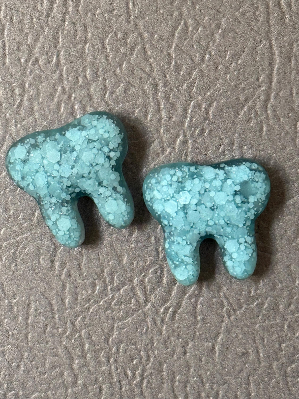 Set of three turquoise resin tooth magnets from Teeth Obsessed, ideal dental office decor notes and magnets.