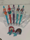 Blue mermaid-themed teeth-shaped pens with matching holders from Teeth Obsessed, designed for fun and functional writing accessories.