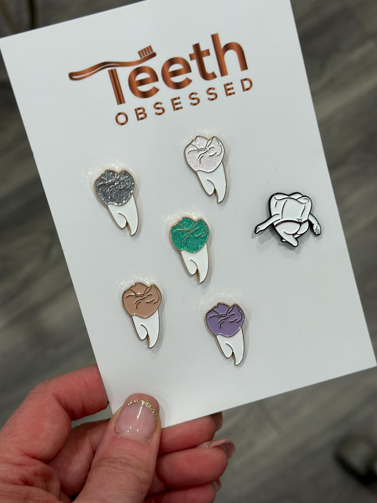 Turquoise Molar Dental Pins from Teeth Obsessed, featuring shirt and pin designs with tooth-themed graphics.